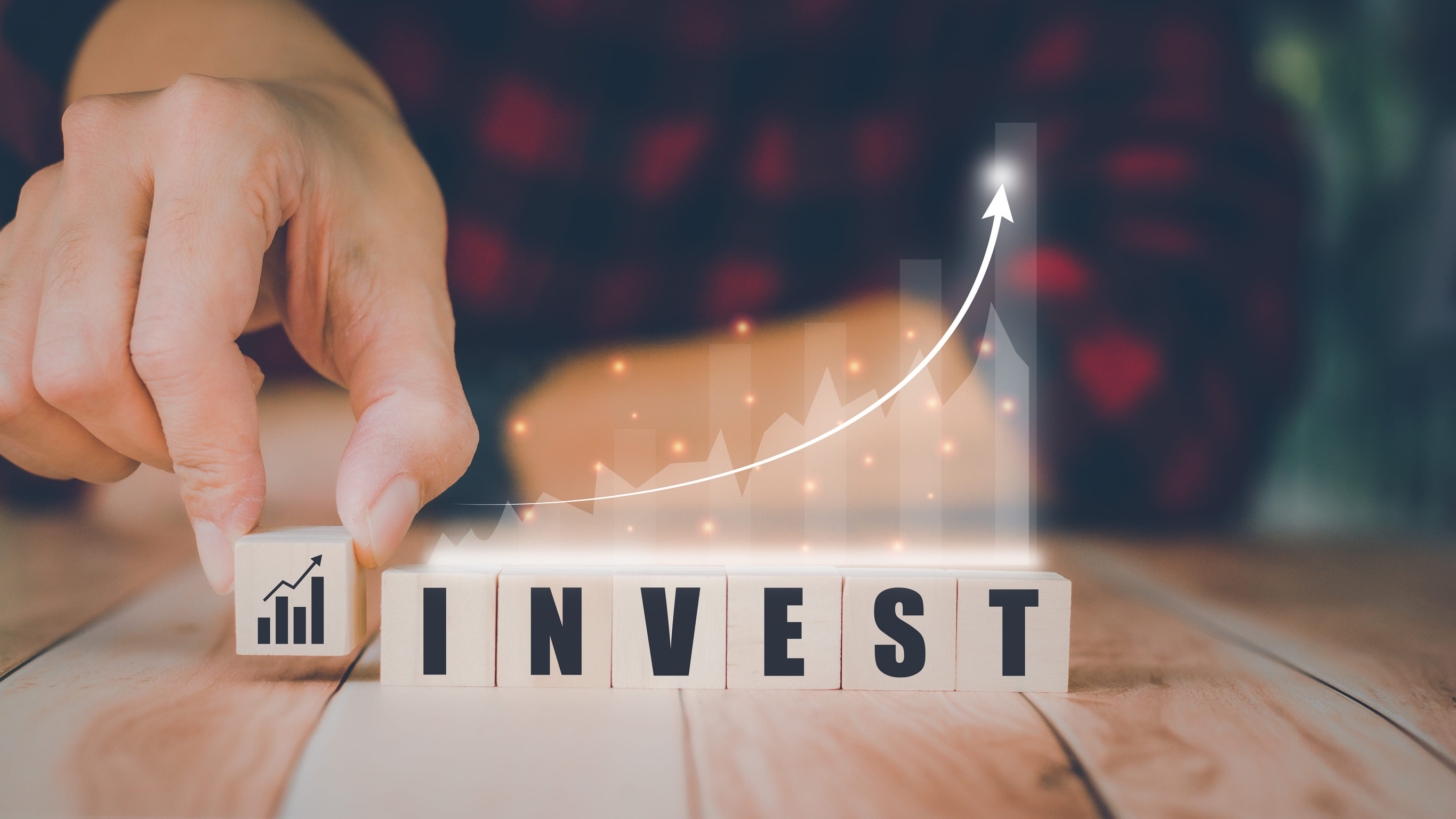 Hand placing block spelling invest growth