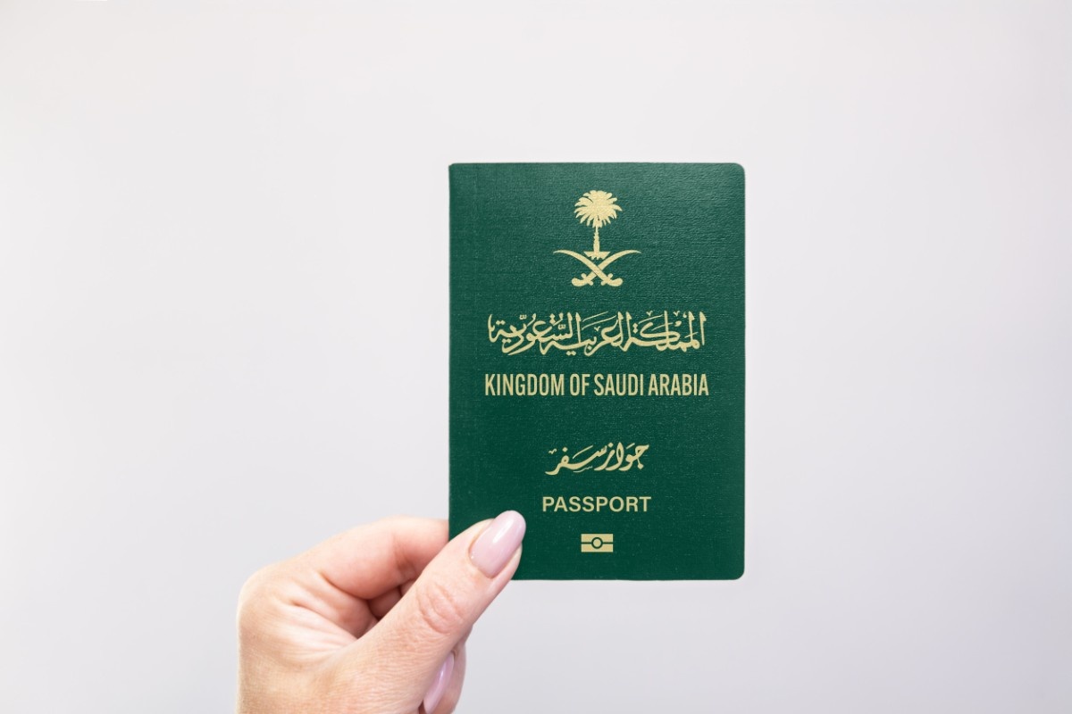 Holding a KSA Passport against a white background